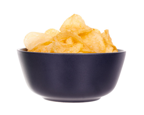 Golden potato chip in dark bowl.