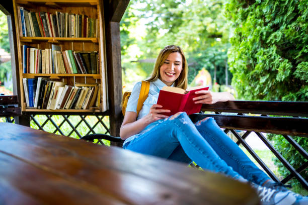 istock Woman reading a book in the open library 1273715556