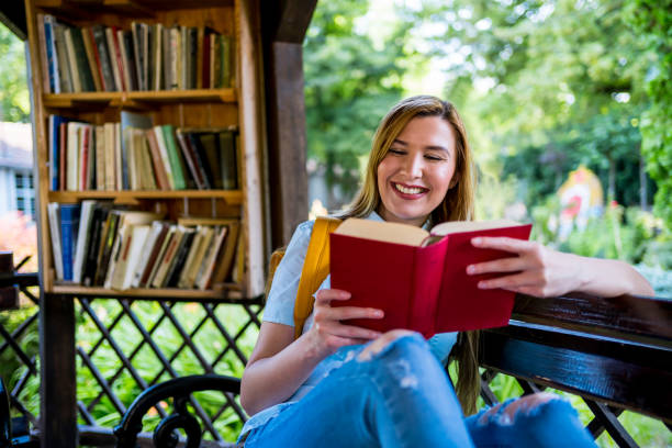 istock Woman reading a book in the open library 1273716492