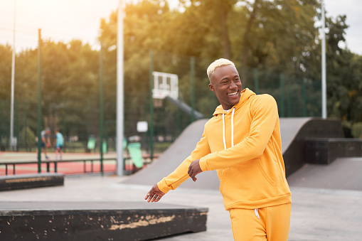 African-american smiling black man yellow hoodie outside Happy emotional afro model guy walking skate park summer day Free space Positive emotions