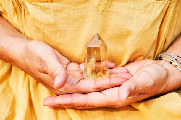 Close up image of Citrine crystal holding by a woman