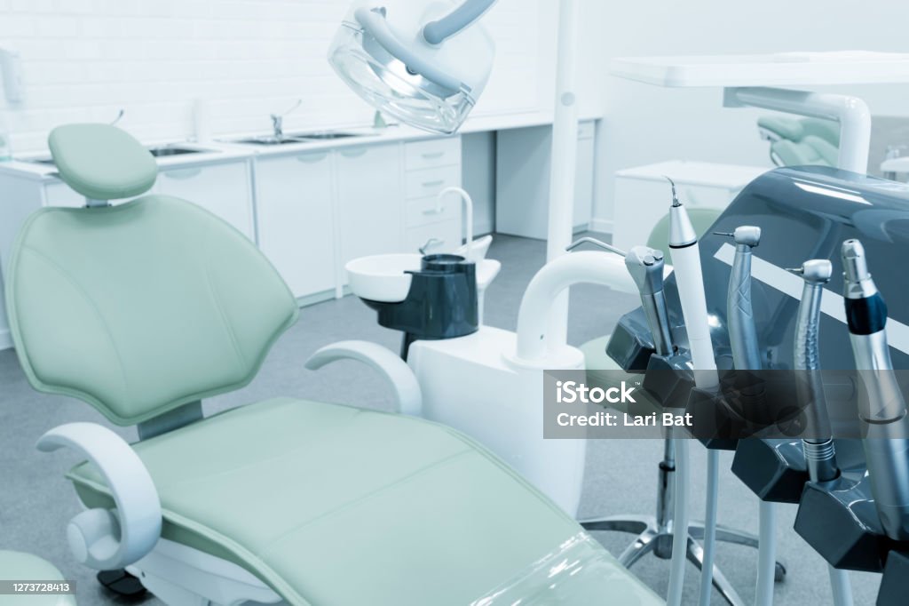 Dental chair and equipment. Patient reception room in a modern medical center. Dental chair and equipment. Patient reception room in a modern medical center. Toned Dentist's Office Stock Photo