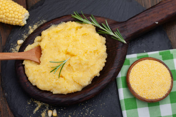 Mamaliga or polenta porridge made out of yellow maize flour Mamaliga or polenta porridge made out of yellow maize flour. Homemade palenta in wooden bowl, traditional meal on Balkan. mamaliga stock pictures, royalty-free photos & images