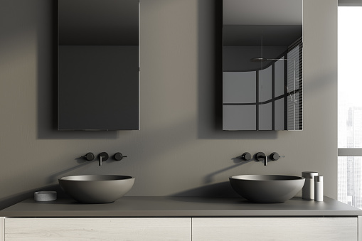 Close up of double sink standing on white countertop in modern bathroom with gray walls. 3d rendering
