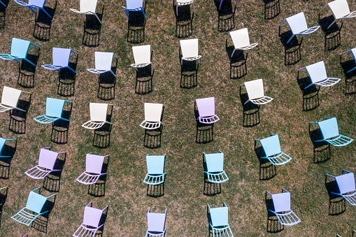 Photo of colourful chairs in a row for an open-air activity. Taken via drone.