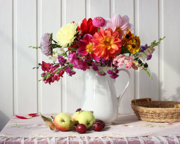 istock autumn still life with garden flowers and fruit on a light background. 1273735995