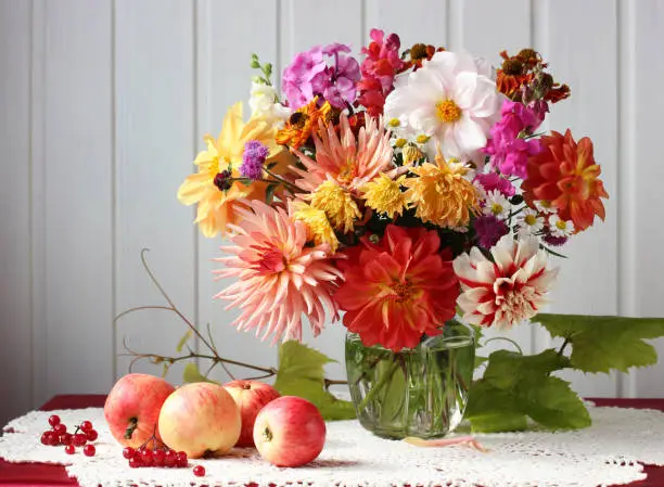 Photo of bouquet of garden flowers, apples and viburnum.