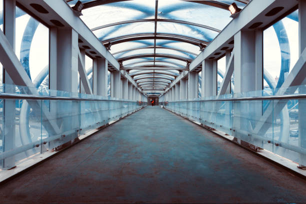 istock Empty dark pedestrian glass metal bridge cross over traffic underneath 1273737193
