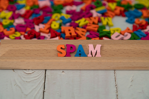 Spam word written with colorful wood alphabet letters.