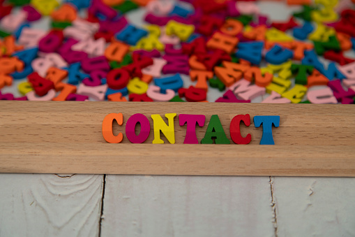 Contact word written with colorful wood alphabet letters.