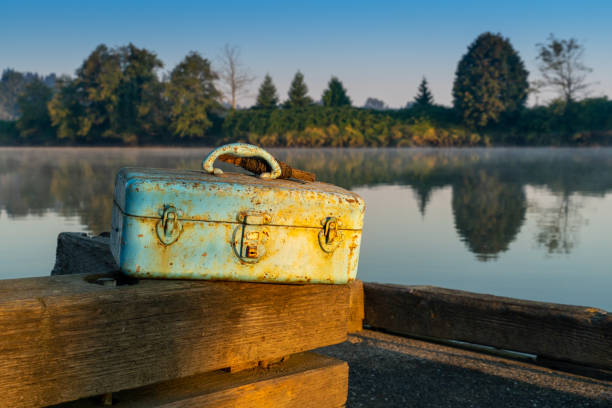 Fishing tackle box at sunrise on the bock dock over the Snohomish River Fishing at sunrise on the Snohomish River, Lowell Park - Everett Washington everett washington state photos stock pictures, royalty-free photos & images