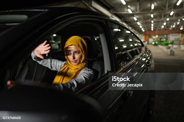 Muslim Woman Covering Her Eyes From Strong Light From Another Car At Night Stock Photo - Download Image Now
