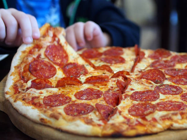 Pizza, delicious appetizing food, children's hands tear off a piece of pizza.