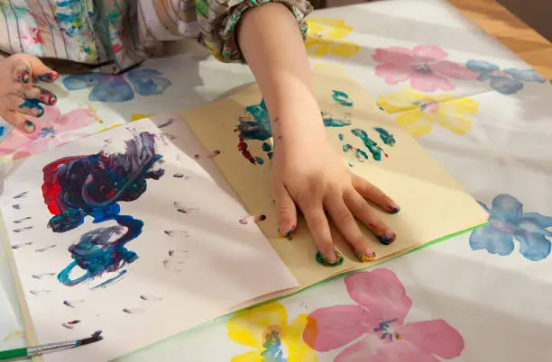 Photo of Hands of a child messing around with paint