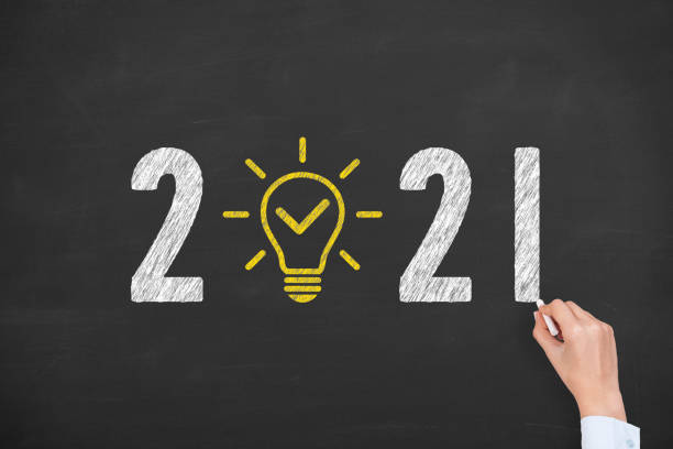 istock Human Hand Drawing New Year 2021 Idea Concepts on Blackboard Background 1273748093