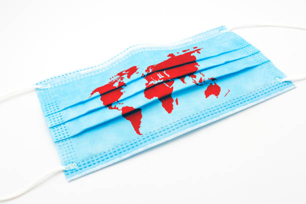 istock Coronavirus concept with face mask and red world map 1273752970