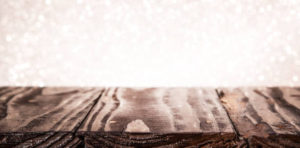 istock Empty Old Wooden Table and White Glittery Defocused Lights in the Background 1273753405