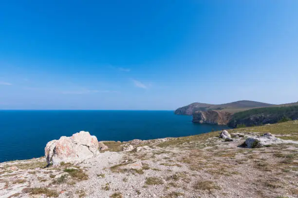 Mountain landscape of Olkhon island. Blue sky over the Maloye More Strait and cape Khoboi. View from cape Sagan Khushum.