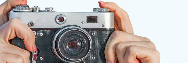 istock Woman hands holding retro camera isolated on red background 1273754750