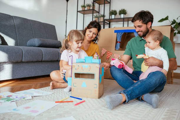 istock Young family at home, making cardboard robot and drawing 1273758680