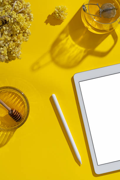 istock Digital tablet mockup, template on yellow background with cup of herbal tea 1273759369