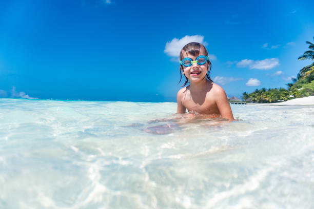 istock Boy with goggles sitting in the sea 1273762827
