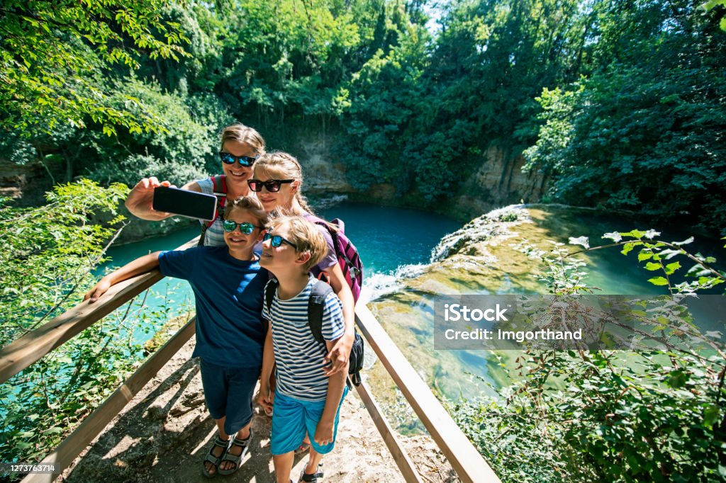 Family hiking in Colle di Val d'Elsa, Tuscany, Italy Mother and three kids hiking near river Elsa in Colle di Val d'Elsa, Tuscany. Family is taking selfies near waterfall on river Elsa.
Nikon D850 Family Stock Photo