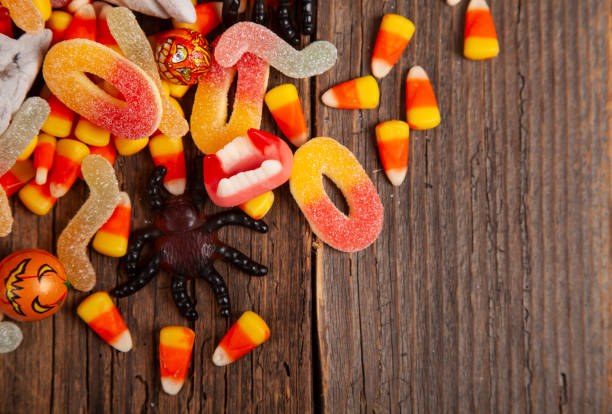 Halloween candy corner border on rustic wooden table Halloween candy corner border on rustic wooden table candy jellybean variation color image stock pictures, royalty-free photos & images