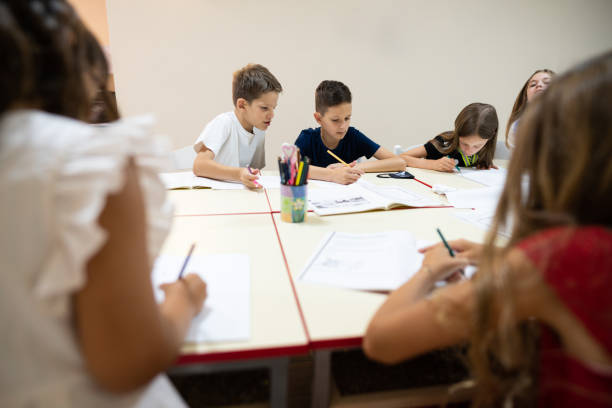 istock One young boy looking at the friend's answer during the class 1273774639