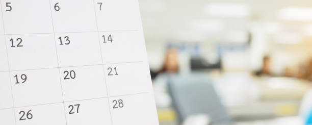 istock Close up white paper desk calendar on table with blurred office interior background 1273778548