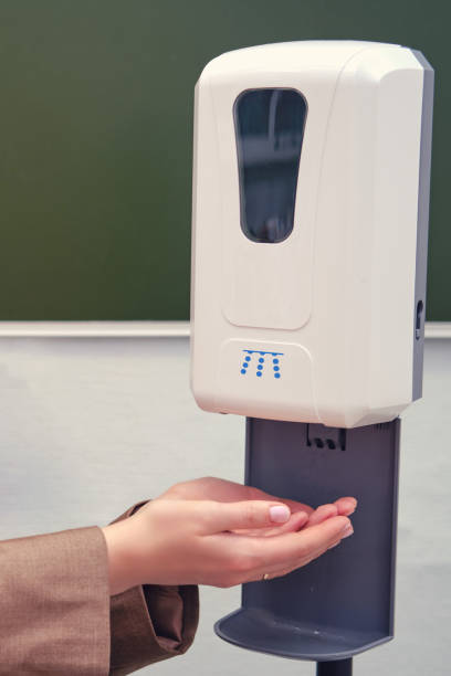 istock A teacher washes his hands in a dispenser with a sanitizer 1273778627