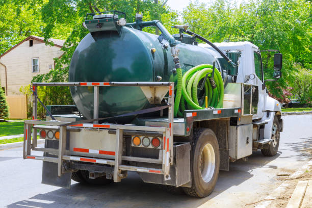 Vacuum waste truck on the cleaning process portable bio toilet cabins in the construction Vacuum waste truck on the cleaning process portable bio toilet cabins at the construction toilet truck stock pictures, royalty-free photos & images