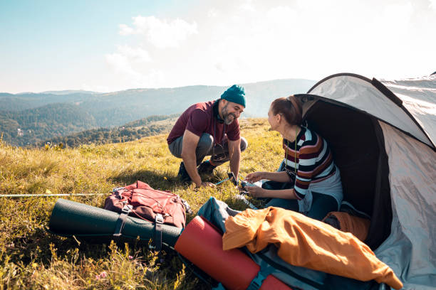istock Young couple setting up a tent 1273793372