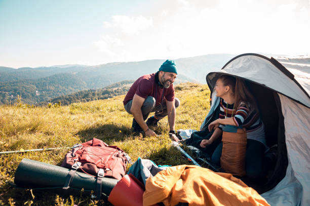 istock Young couple setting up a tent 1273793953