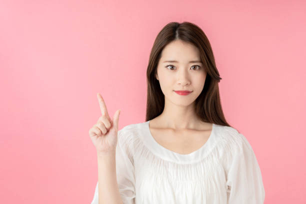 istock Young asian woman pointing at copy space. 1273794033