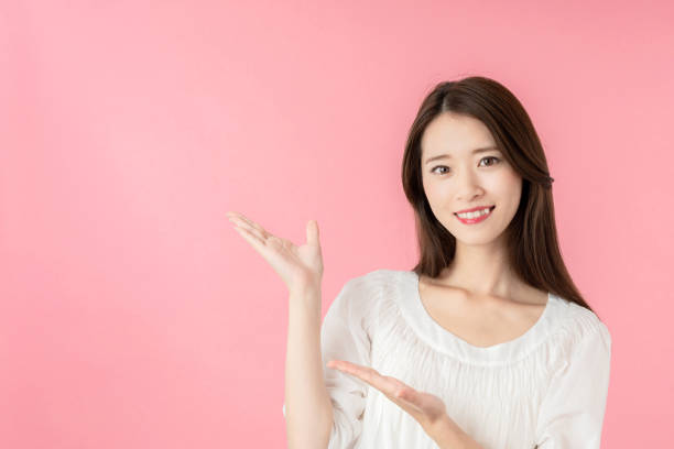 istock Young asian woman pointing at copy space. 1273794038