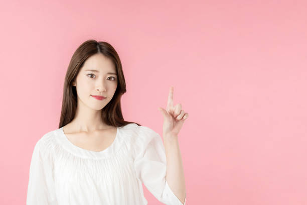 istock Young asian woman pointing at copy space. 1273794077