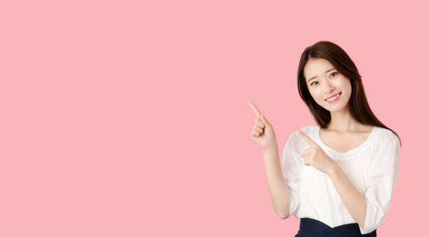 istock Young asian woman pointing at copy space. 1273794089