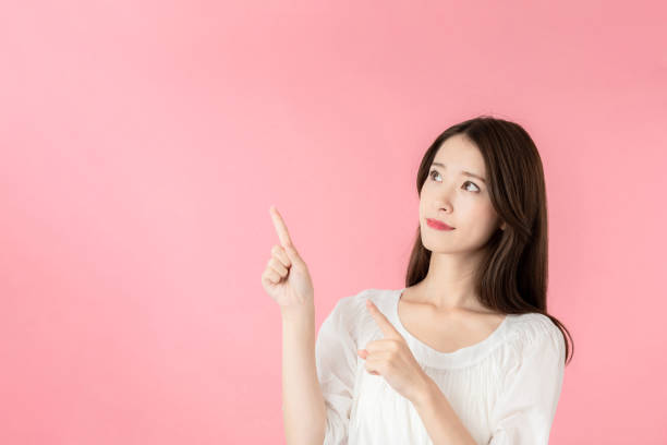 istock Young asian woman pointing at copy space. 1273794093