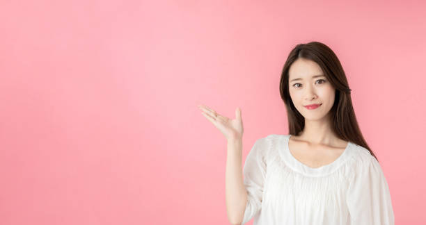 istock Young asian woman pointing at copy space. 1273794109
