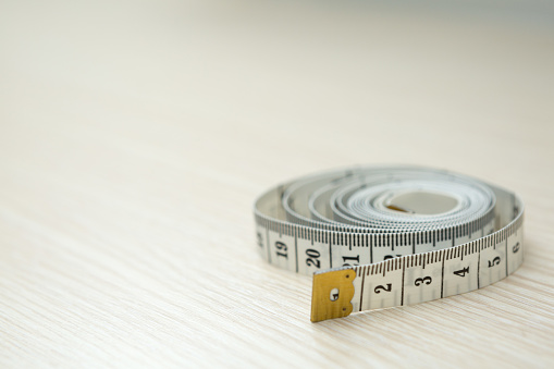 Tape measure on wood background and copy space