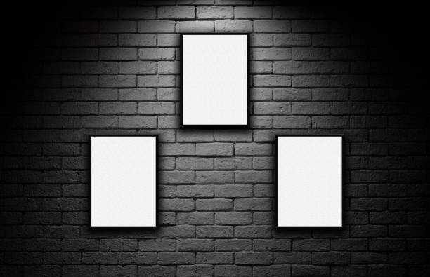 istock Blank posters on dark brick wall with spotlight display 1273797315