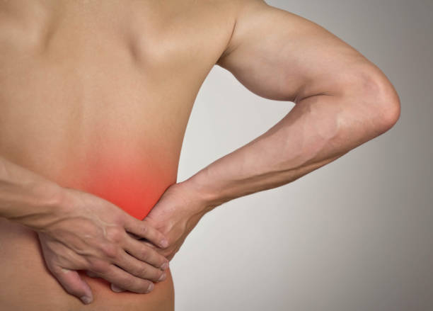 istock Lower back pain in a man. Highlighted in red. On a gray background. Close up 1273801448