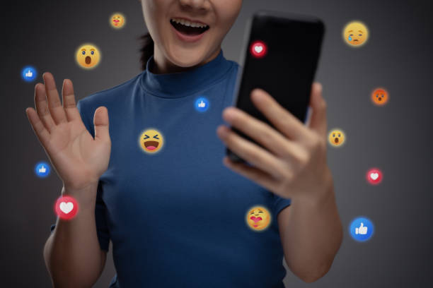 istock Asian woman using smart phone for social media with emoticon bubble. 1273804073