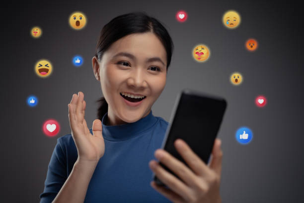 istock Asian woman using smart phone for social media with emoticon bubble. 1273804085