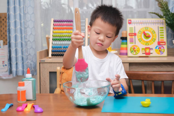 istock Cute  Asian 4 years old boy having fun making fluffy slime, Young kid having fun playing and being creative by science experiment homemade toy called Slime 1273805578