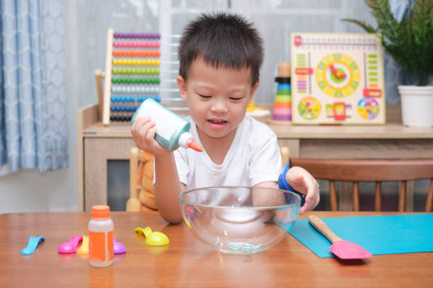 istock Cute  Asian 4 years old boy having fun making fluffy slime, Young kid having fun playing and being creative by science experiment homemade toy called Slime 1273805580