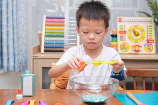 istock Cute  Asian 4 years old boy having fun making fluffy slime, Young kid having fun playing and being creative by science experiment homemade toy called Slime 1273805583