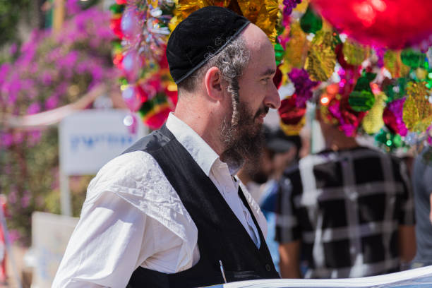 TEL AVIV, ISRAEL OCTOBER 4, 2017 Jewish man holding a Palm branch on Sukkot four species festival. Sukkah decorations