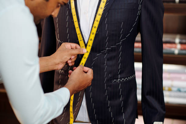 Creating bespoke suit Profesional tailor making bespoke suit for client in his modern stidui tailor stock pictures, royalty-free photos & images